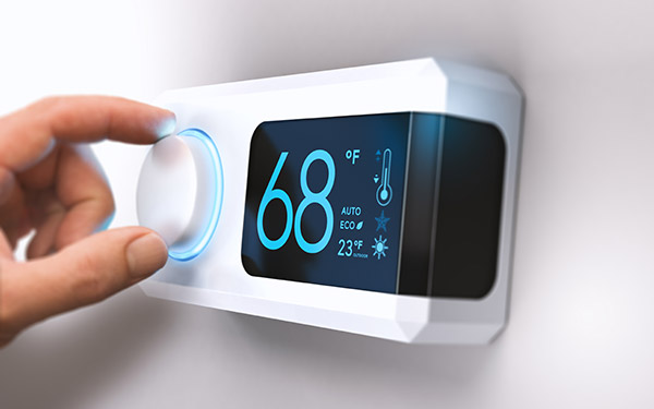 person setting thermostat to 68 degrees